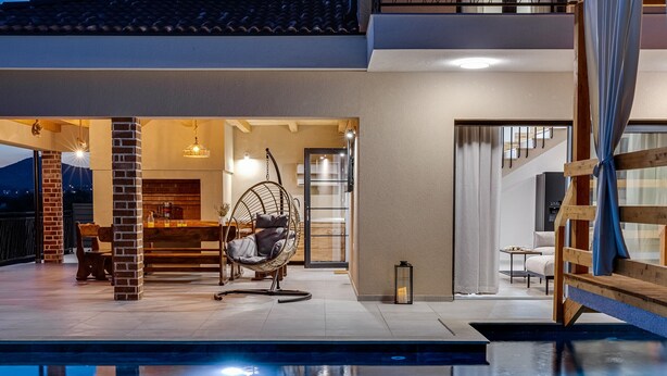 A modern outdoor pool area with a hanging chair, a wooden bench, and a staircase leading to an upper level. - Villa Alba Zadarvillas (Pakostane)