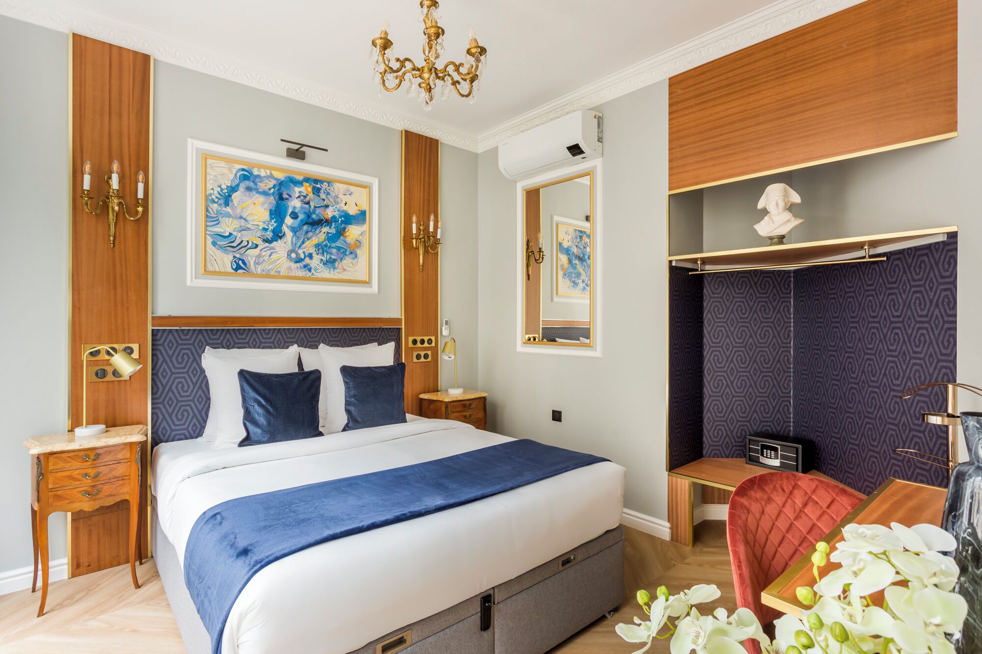 Habitación de hotel con una cama grande, un escritorio, una silla y un armario.