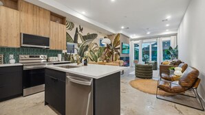 A modern kitchen with a central island, wooden cabinets, and a large window. - `Bali in Houston`/8BR/8Bath/Heated Pool/Sleeps 23 (Houston)