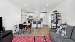 A modern apartment with a kitchen, dining area, and living room.