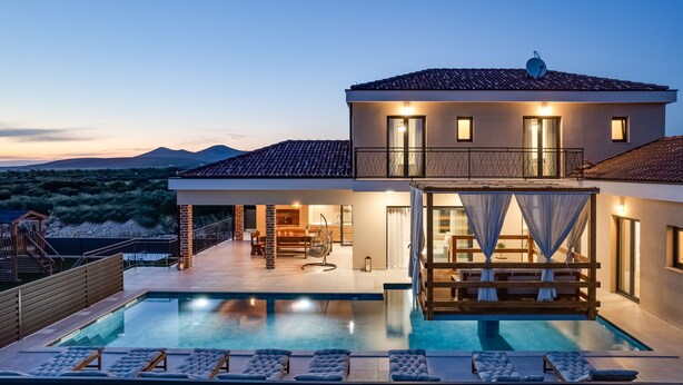 A modern house with a swimming pool, outdoor seating, and a view of the mountains. - Villa Alba Zadarvillas (Pakostane)