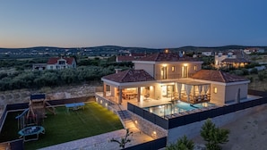 A modern house with a swimming pool, a patio, and a view of the surrounding landscape. - Villa Alba Zadarvillas (Pakostane)