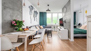 Un salon moderne comprenant un coin repas, un canapé et un téléviseur.