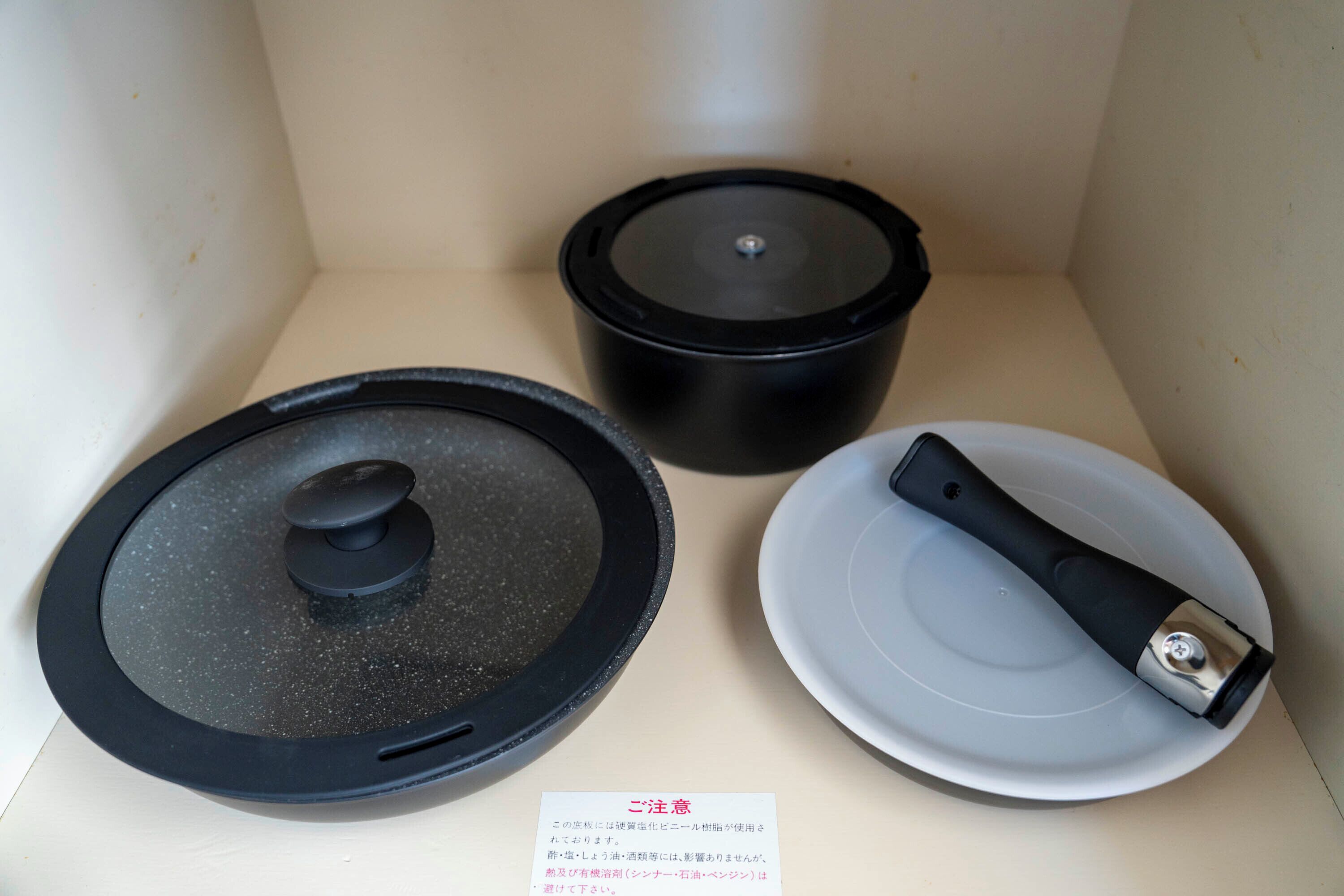 A kitchen with a stove, a pot, and a knife on a plate.