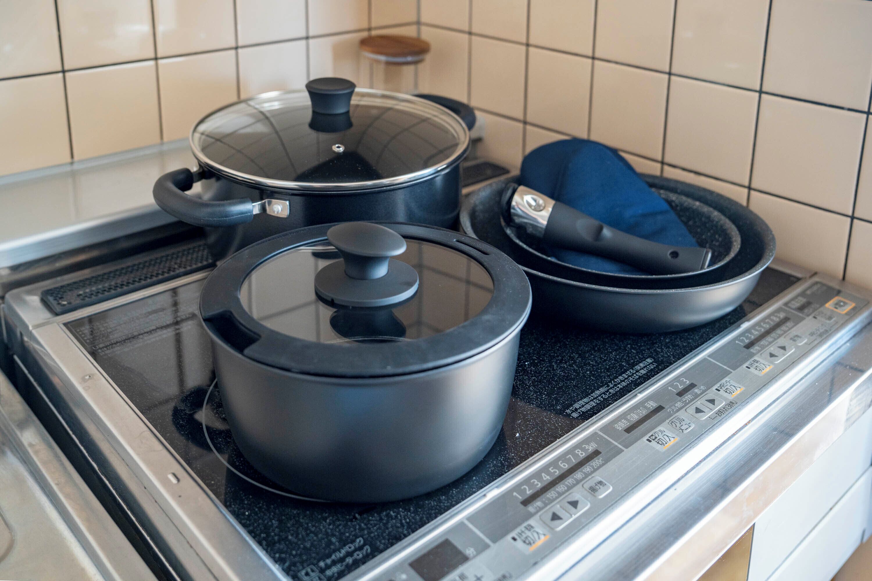 A kitchen with a stove, pots, and a blue cloth.