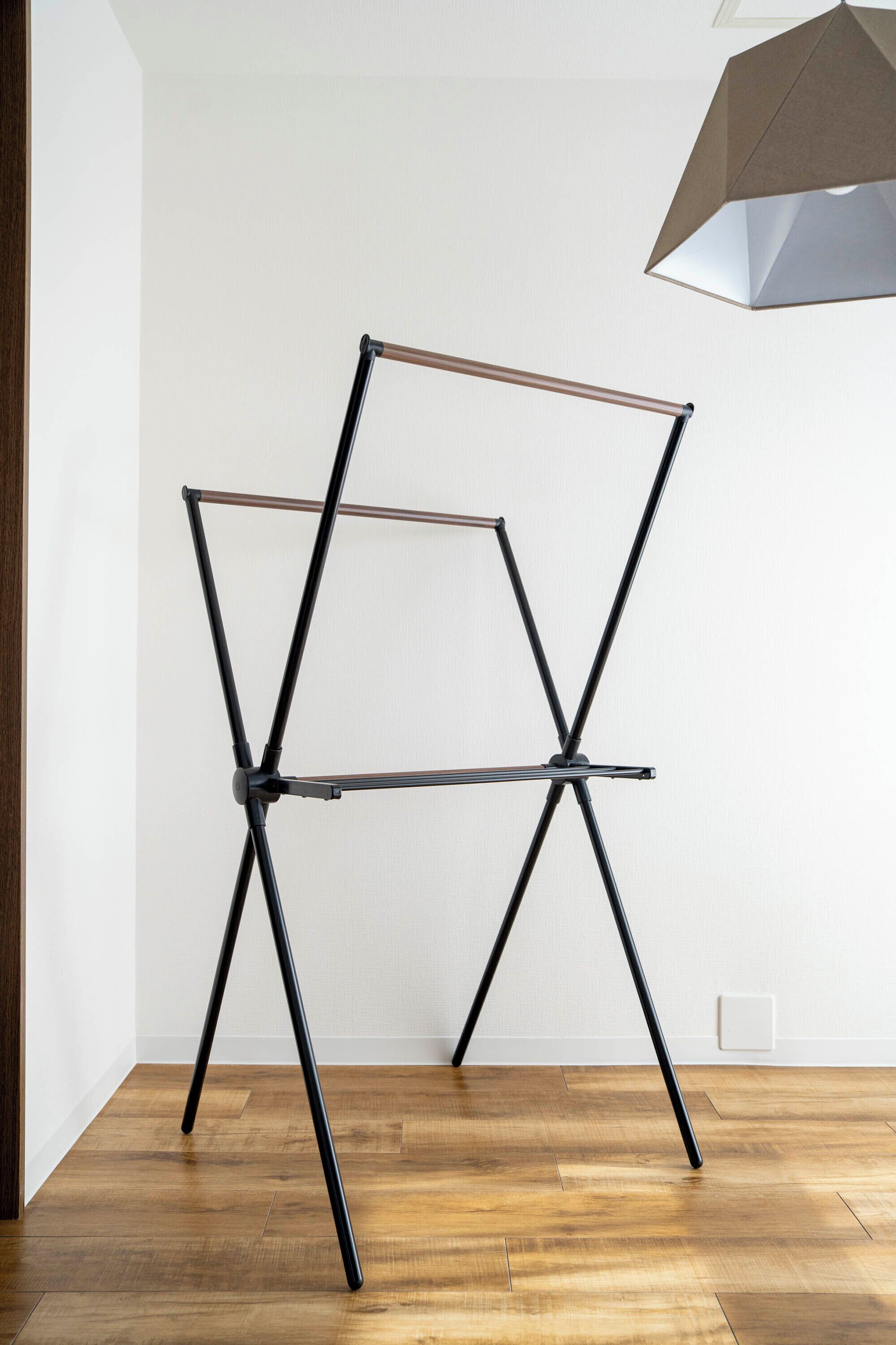A room with a wooden floor, a metal folding chair, and a ceiling light fixture.