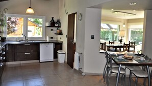 Una cocina moderna con lavavajillas, un lavaplatos y un comedor con mesa y sillas.