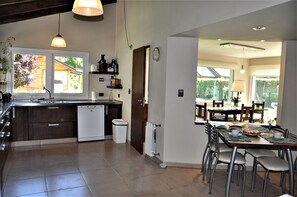 Una cocina moderna con lavavajillas, un lavaplatos y un comedor con mesa y sillas.