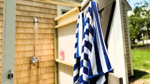 Une façade en bois, une porte en métal et une serviette suspendue à un crochet.