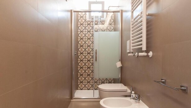Ein Badezimmer mit Dusche, Toilette und Waschbecken.