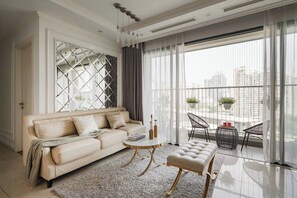 Apartamento standard, 1 cama King e sofá-cama, sacada, vista para a cidade | Área de estar