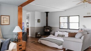 A cozy living room with a sofa, a wooden coffee table, a lamp, and a fireplace.