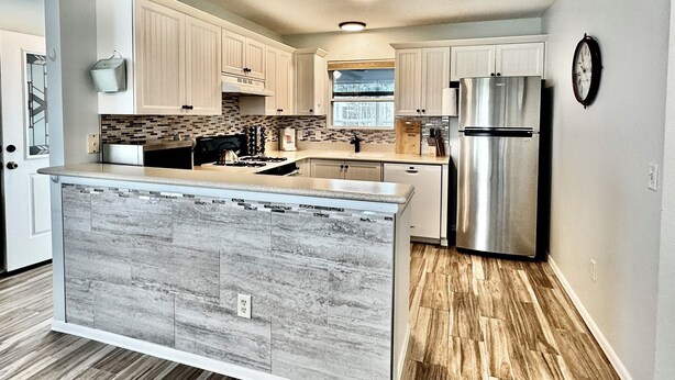 A modern kitchen with a central island, stainless steel appliances, and light wood cabinetry. - Polo Garden Villa - 1/1 Villa On the Polo Field w/ Amazing Garden in The Village of Santiago (Santiago, The Villages)