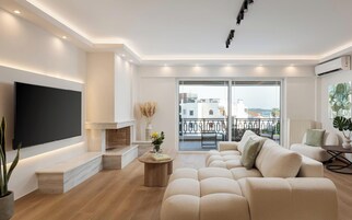 Una sala de estar moderna con un televisor de pantalla plana, chimenea, un conjunto de sofás y un balcón con vistas.