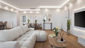 Una sala de estar moderna con un sofá modular, un comedor con mesa y sillas, y un televisor de pantalla plana montado en la pared.
