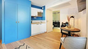 Una cocina moderna con armarios azules, una encimera de madera y una zona de comedor con mesa y sillas.