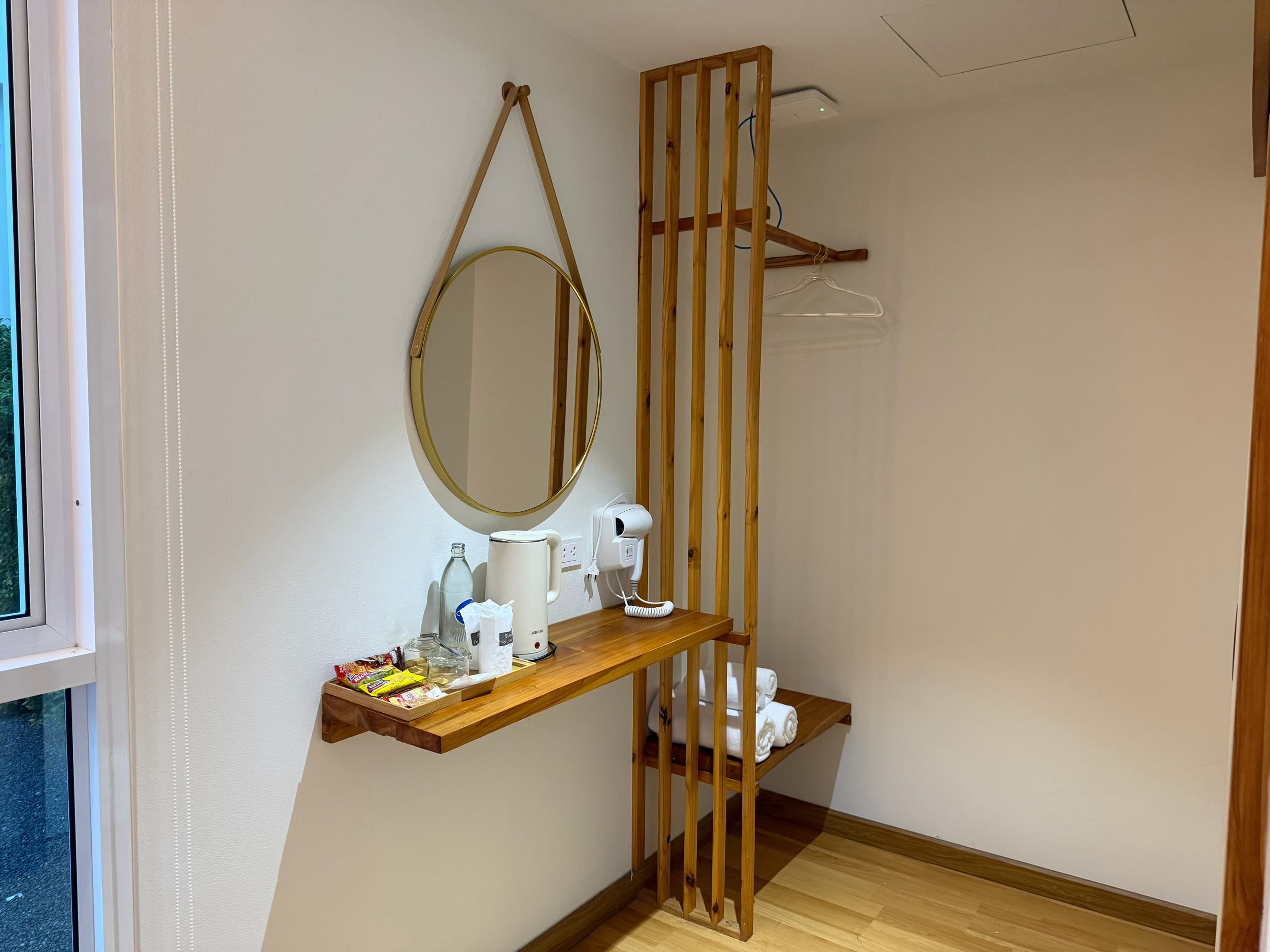 A bathroom with a wooden vanity, a mirror, a towel rack, and a toilet.