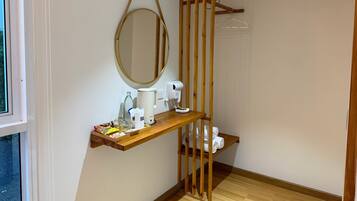 A bathroom with a wooden vanity, a mirror, a towel rack, and a toilet.
