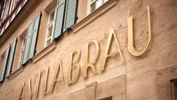 A building facade with the name "ANTLABRAU" in large, gold letters. - Economy Hotels Kronach (Kronach)