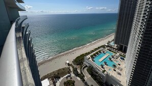 A high-rise hotel with a pool and beach view.