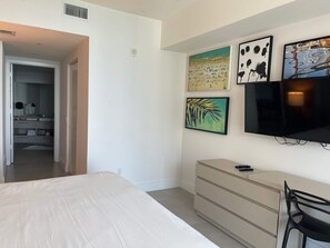 A bedroom with a bed, a dresser, a TV, and artwork on the wall. - Wonderful Views at Lyfe Resort @rent4us (Hollywood)