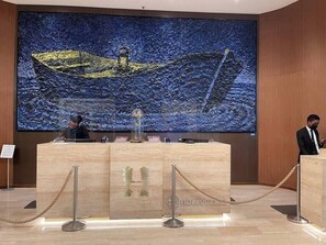 A reception desk with a large painting of a boat on water behind it. - Wonderful Views at Lyfe Resort @rent4us (Hollywood)