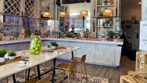 A modern bar area with a central island, bar stools, and a variety of bottles and glasses on shelves. - Wonderful Views at Lyfe Resort @rent4us (Hollywood)