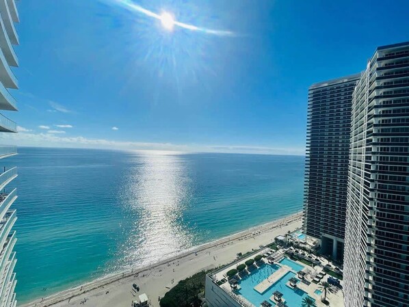 A high-rise hotel with a pool and beach view.