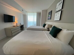 A hotel room with two beds, a desk, a chair, a TV, and a window with curtains. - Wonderful Views at Lyfe Resort @rent4us (Hollywood)