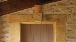 Entrada con pared de piedra y puerta de madera marcada con el número 2.