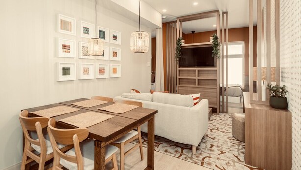 A modern living room with a dining area, featuring a wooden table, chairs, a sofa, and a TV. - Loft Folk 103 Downtown Quebec City (Québec City)