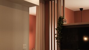 A modern living room with a TV, wooden shelving, and a plant. - Loft Folk 103 Downtown Quebec City (Québec City)