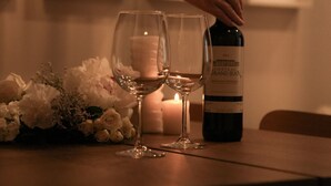 A bottle of wine on a table with two glasses and a candle. - Loft Folk 103 Downtown Quebec City (Québec City)