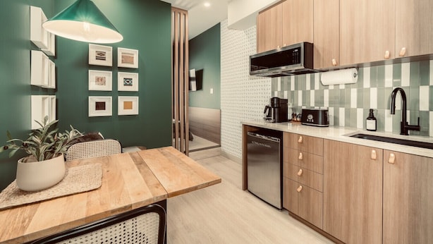 Una cocina moderna con armarios de madera, microondas, cafetera y lavavajillas.