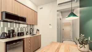 Una cocina moderna con armarios de madera, lavavajillas de acero inoxidable, cafetera y pileta.