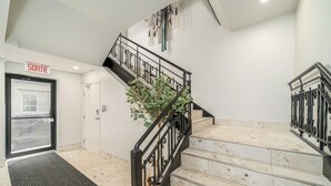 Una escalera con barandillas negras, un felpudo y un letrero que dice 'SORTIE'.
