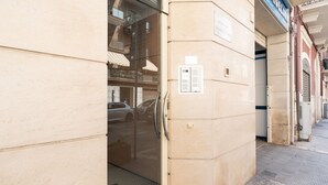 A building entrance with a glass door, a metal handle, and a small sign on the wall. - Levante 65 by Wonderful Italy (Bari)