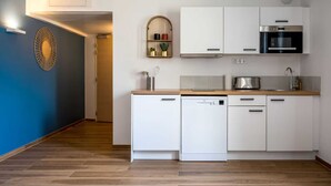 A modern kitchen with white cabinets, a stainless steel oven, and a dishwasher. - Suite Raphaël #4- Rooftop & Air Conditioning (Vanves)