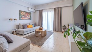 A modern living room with a sofa, coffee table, and a flat-screen TV. - Residence City Luna, Apartment (Rodos)