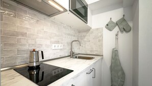A compact kitchen with a built-in stove, a sink, and a window above the countertop. - Caracas: perfect room to live and share in Madrid (Madrid)