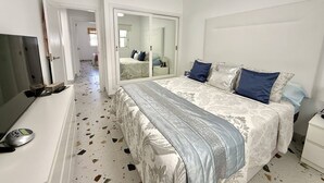 A bedroom with a bed, a TV, a wardrobe, and a mirror. - Villa Stay&Enjoy (Caleta de Fuste)