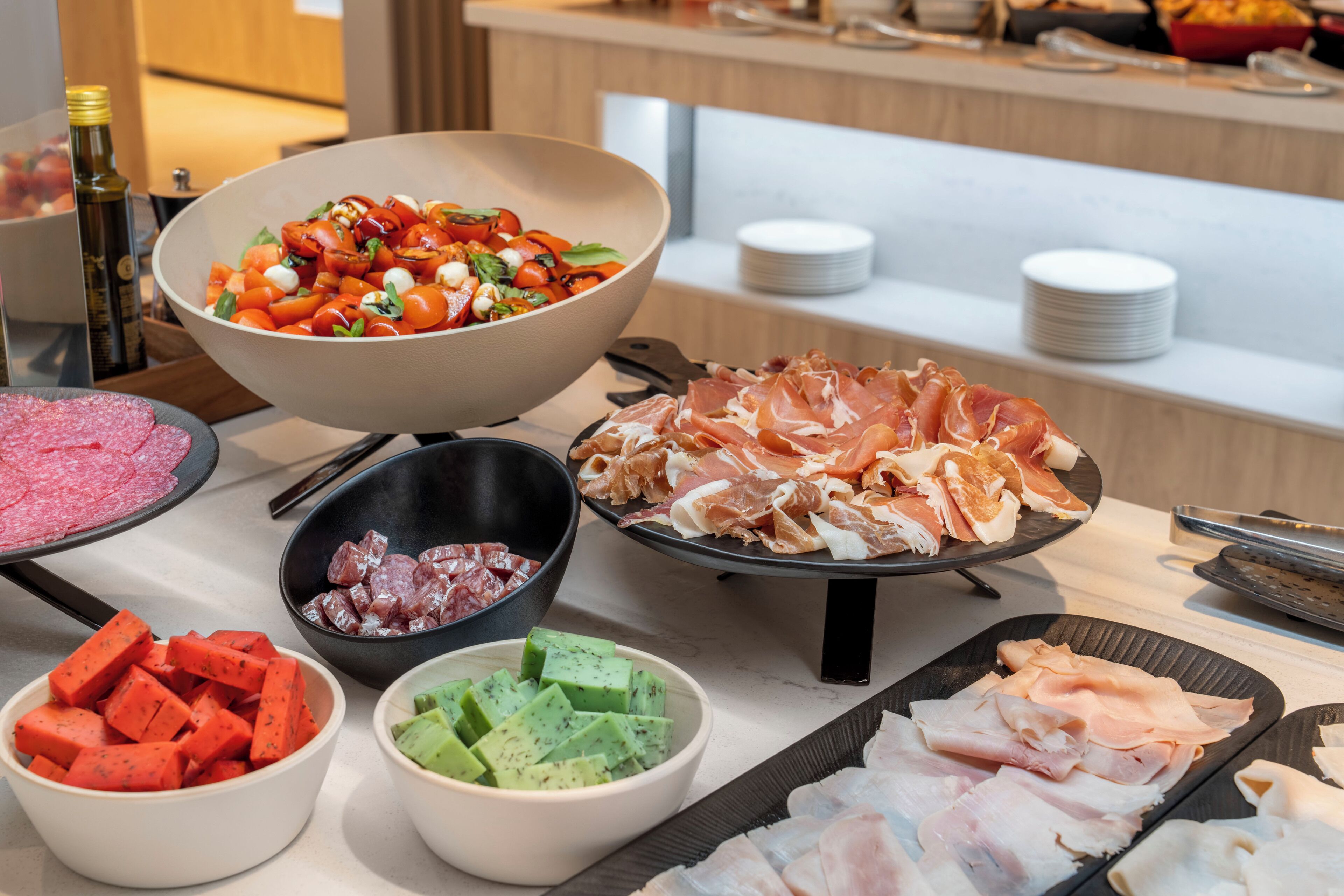 A buffet with various food items including a bowl of salad, sliced meats, and other dishes.