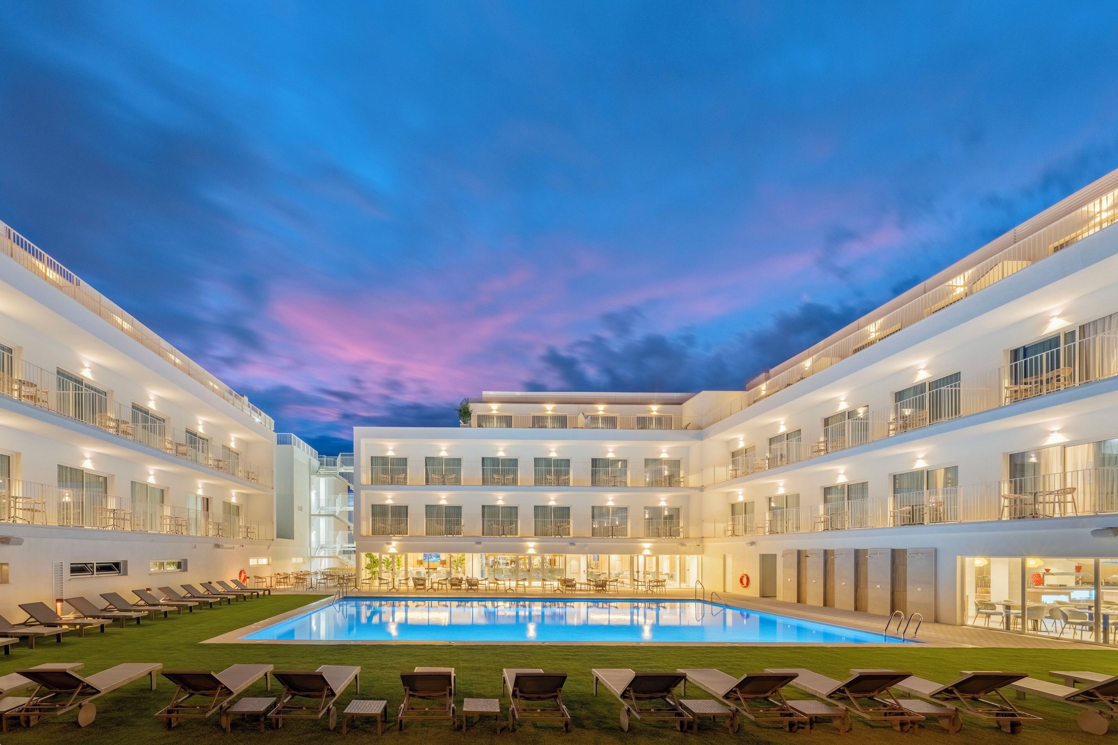 Una piscina al aire libre, sombrillas, tumbonas