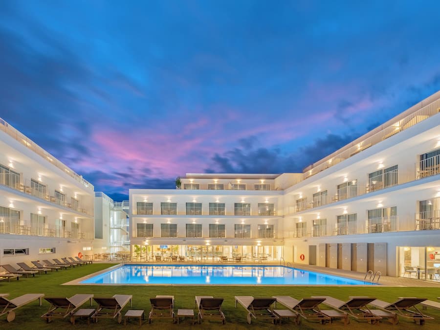 Een buitenzwembad, parasols bij het zwembad en ligstoelen