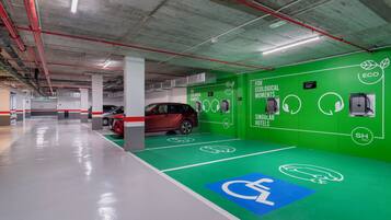 Een parkeergarage met groene wanden, een rode auto en een blauw gehandicaptenparkeerbord.