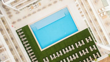 Een buitenzwembad, parasols voor strand/zwembad