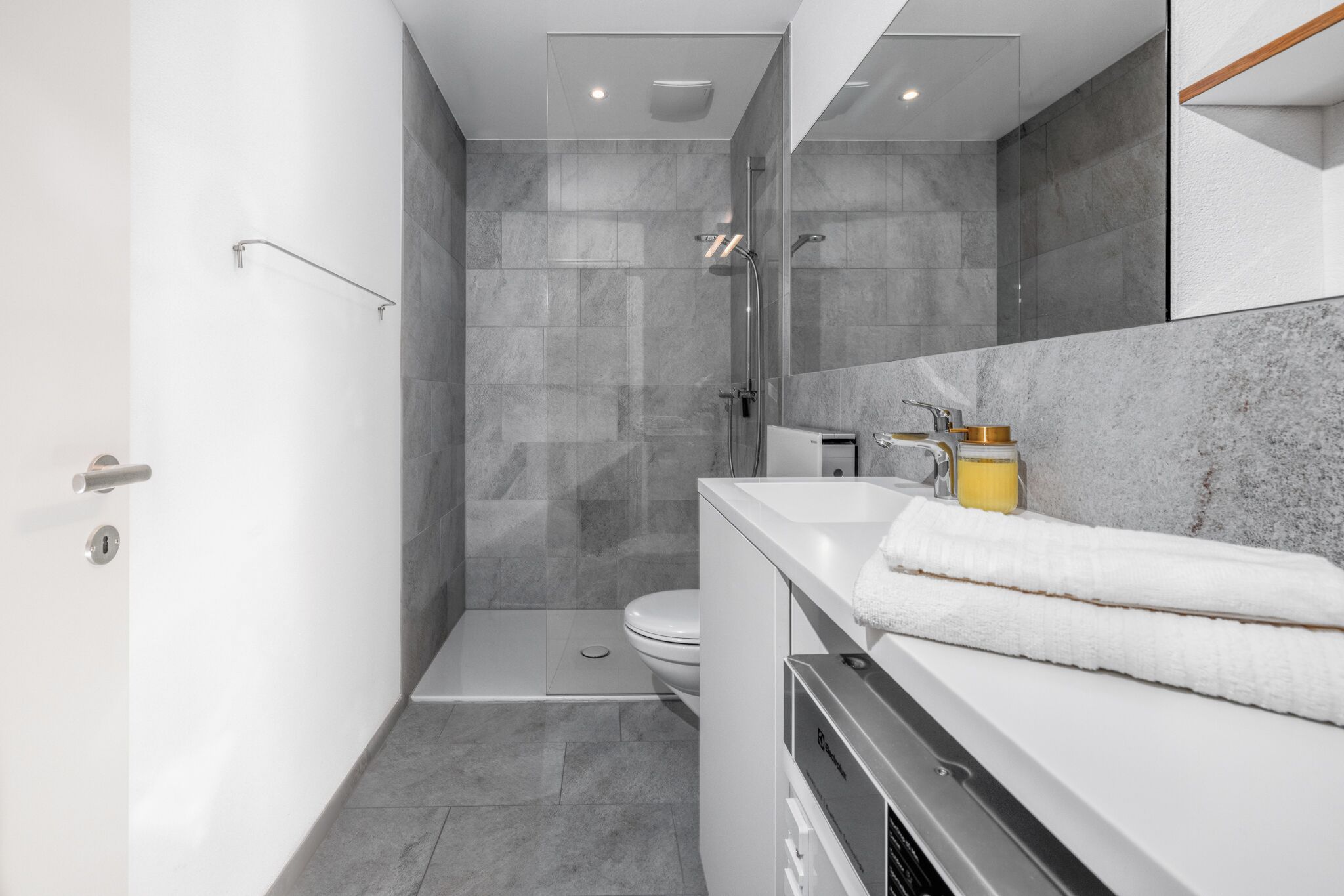 Un baño moderno con ducha, inodoro y lavamanos.
