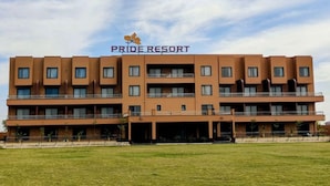 Un immeuble à plusieurs étages sur lequel on peut lire l’inscription « PRIDE RESORT ».