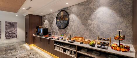 A modern kitchen with a marble floor, wooden cabinets, and a fruit display.