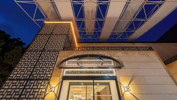 The exterior of Hotel Molina Plaza with a geometric facade and a clear sign above the entrance.